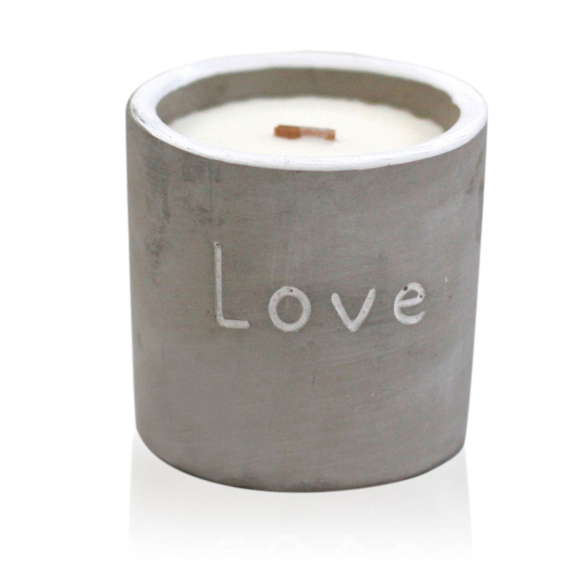 Candle in a concrete holder with 'Love' engraved on a white background