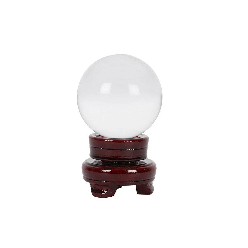 Crystal ball on a wooden stand against a white background