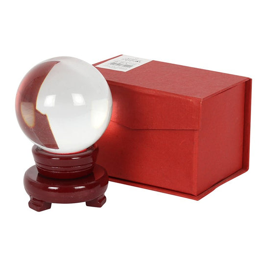 Decorative crystal ball on a red stand with a matching red box on a white background