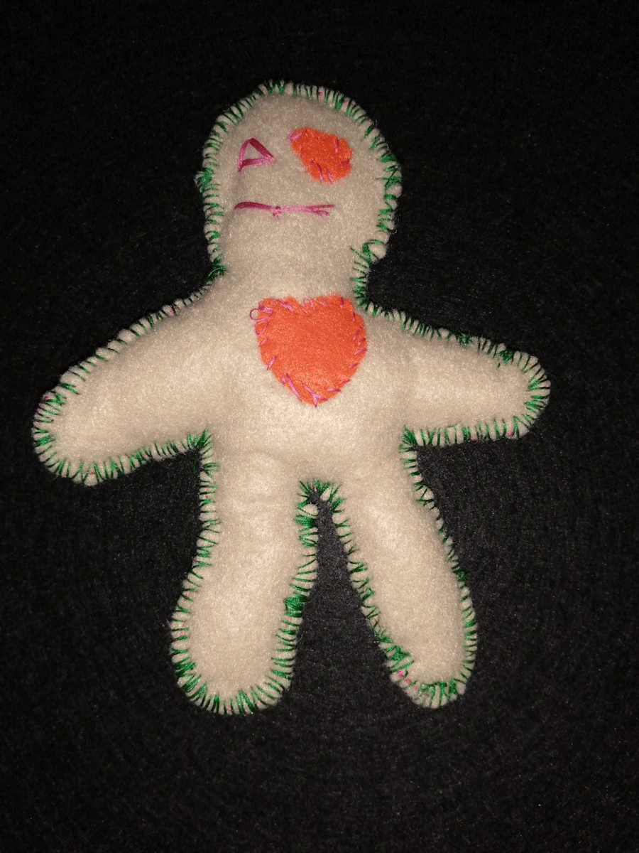 Handmade cream poppet with an orange heart and eye and a red stitched eye and mouth