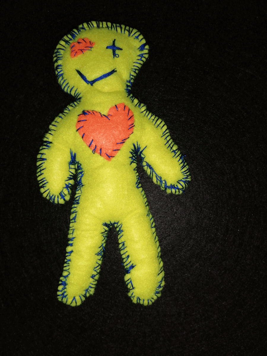 Handmade yellow poppet with an orange heart and eye and a blue stitched eye and mouth