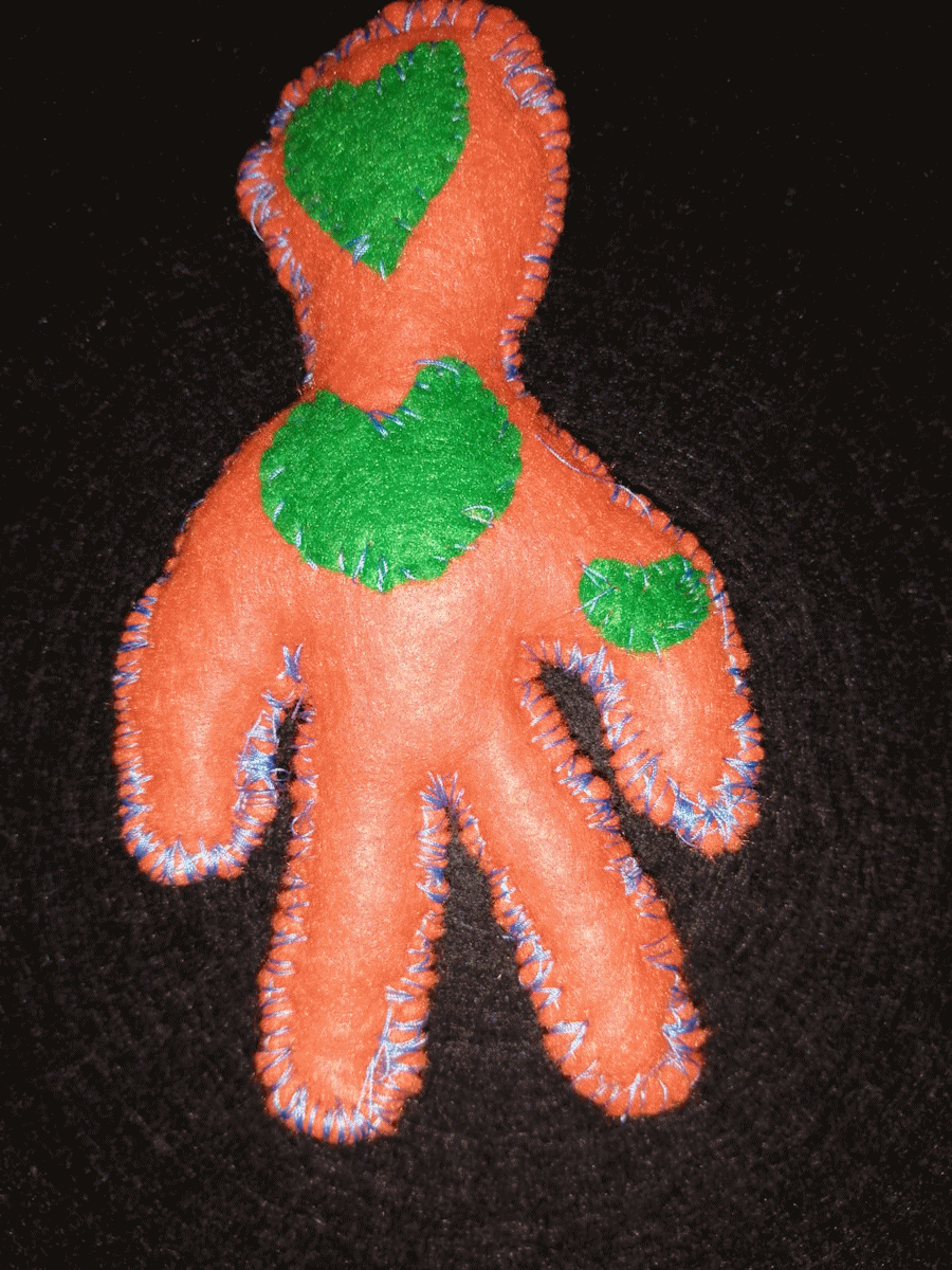 Handmade orange poppet with an green heart and eye and a green heart on arm