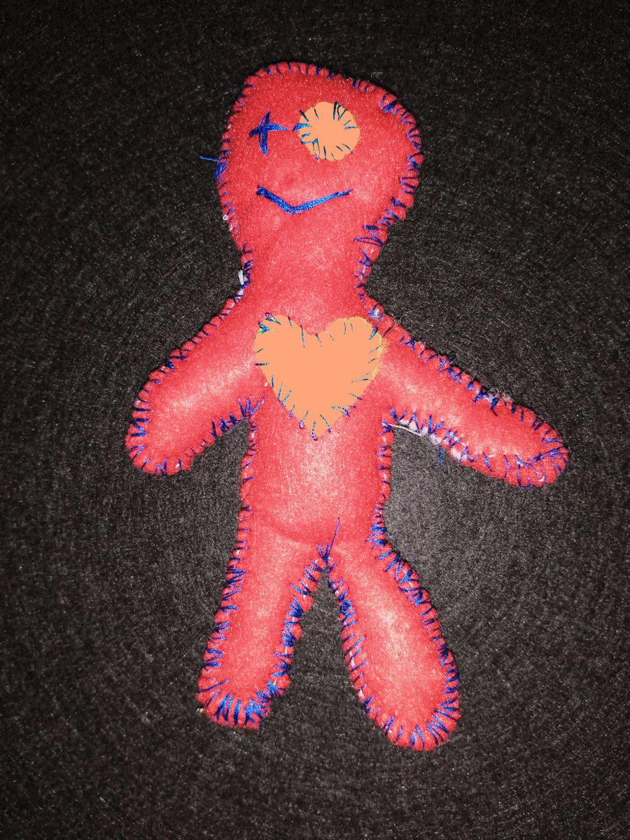 Handmade orange poppet with an orange heart and eye, and a blue stitched eye and mouth