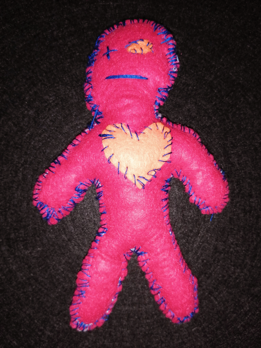 Handmade red poppet with an orange heart and eye and a blue stitched eye and mouth