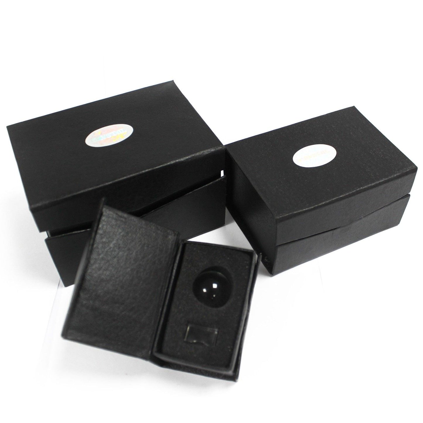 Black jewelry box with a round black object inside on a white background