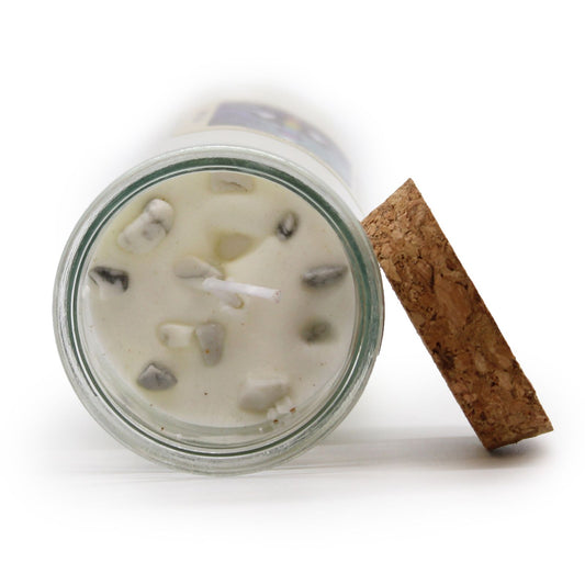 Glass jar with a candle inside, cork lid on a white background
