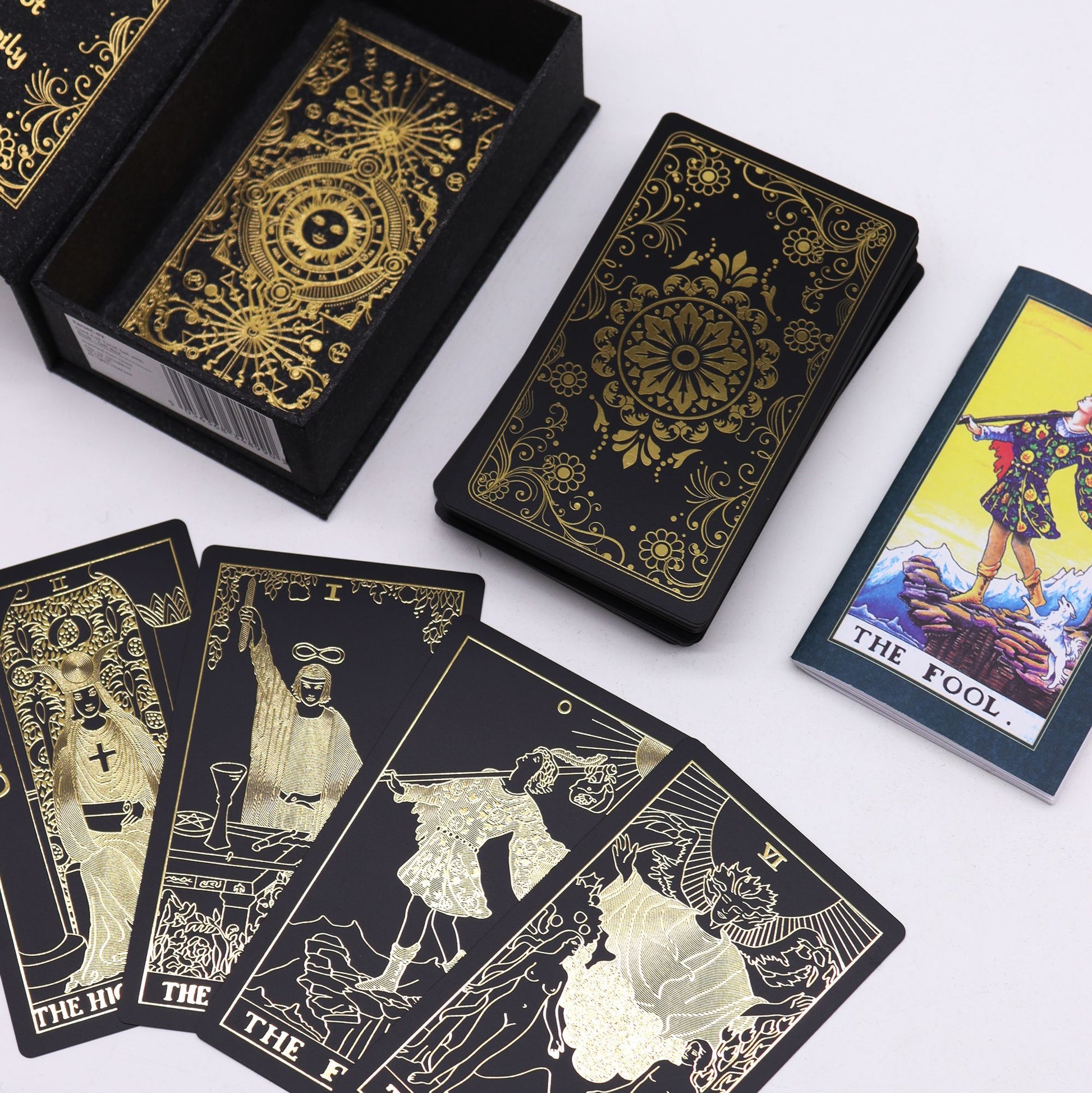 Black and gold tarot cards with intricate designs on a white background