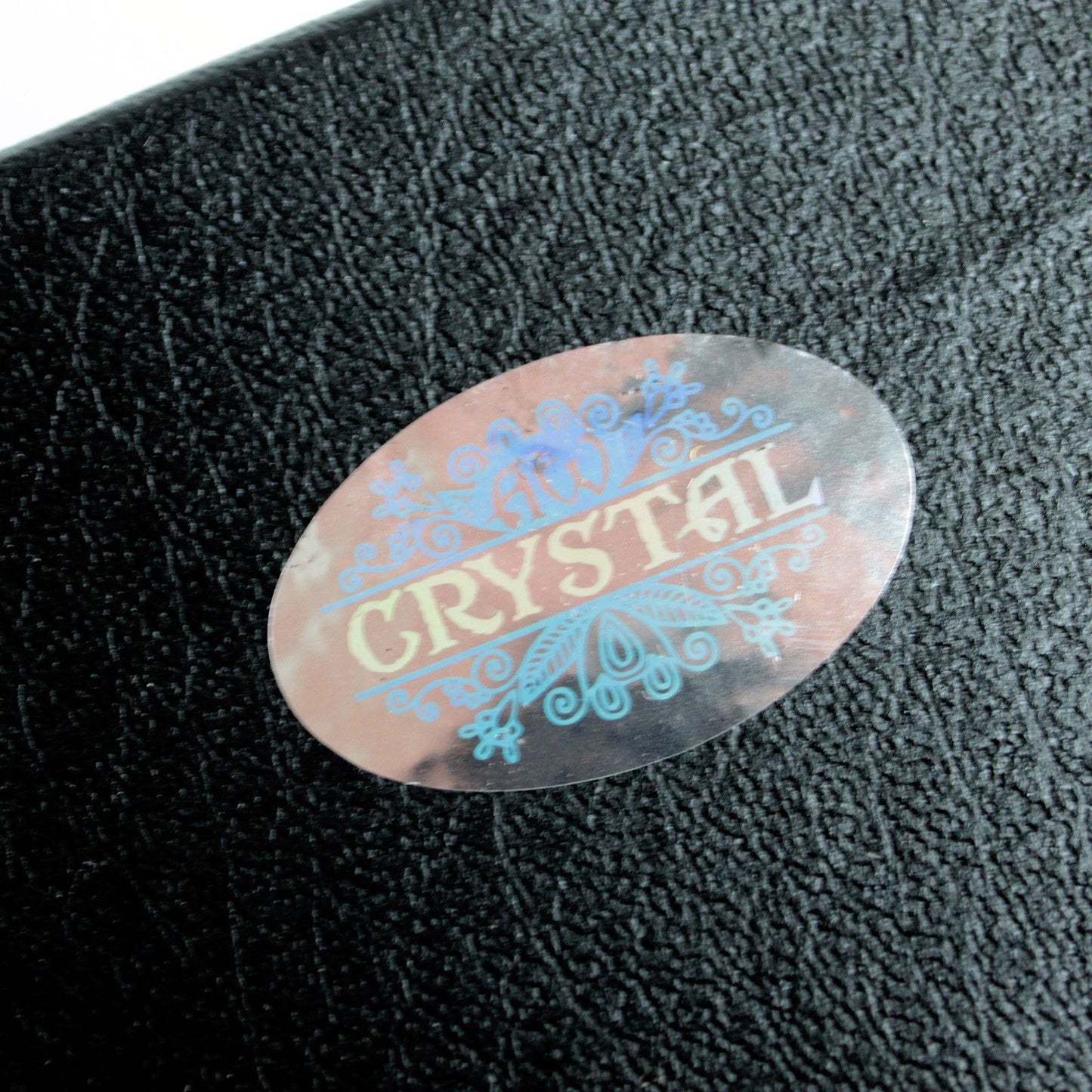 Holographic 'Crystal' label on a textured black surface