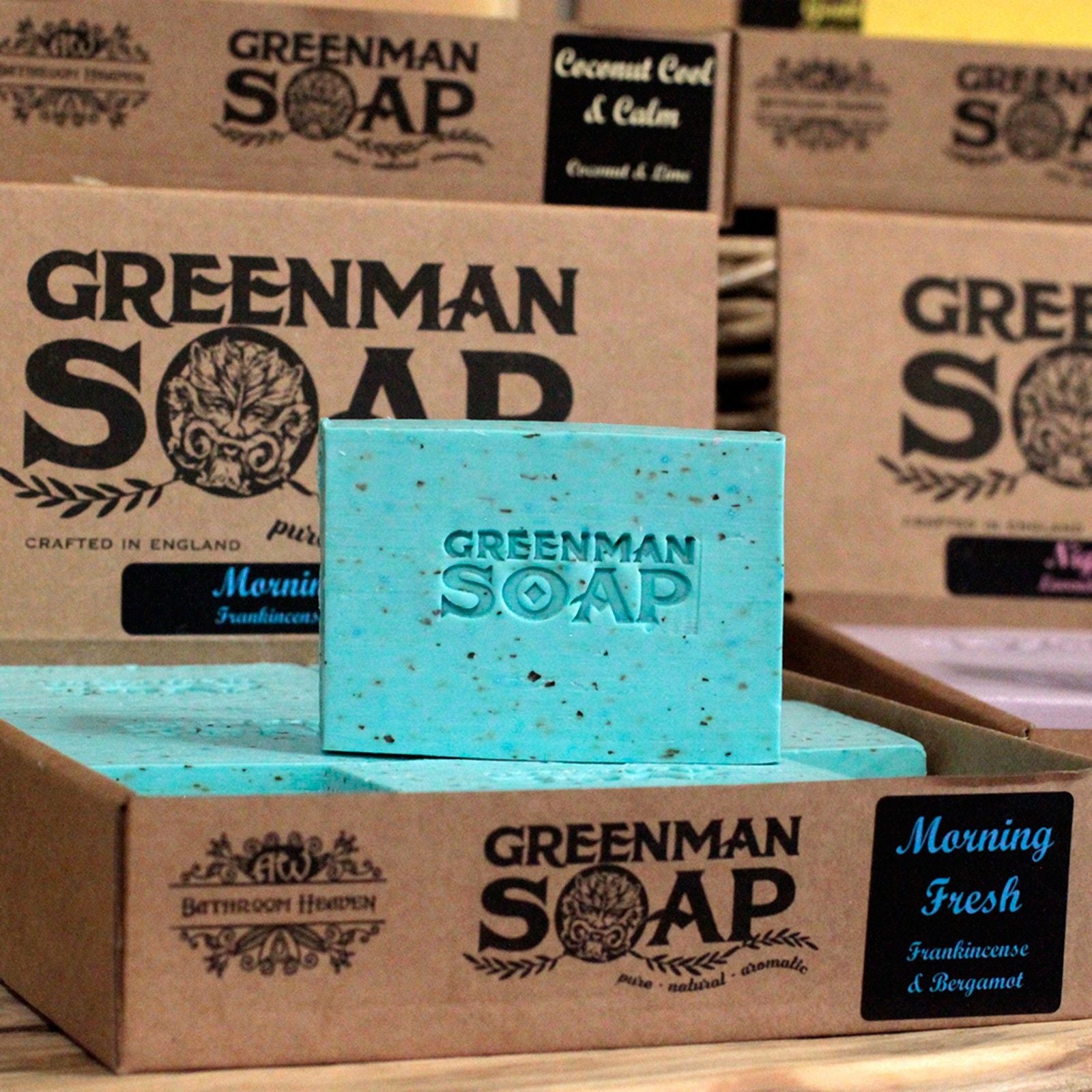 Greenman Soap bars and boxes on a wooden surface