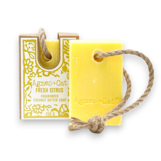 Yellow Citrus soap bar with a rope and packaging labeled 'Agnes + Cat' on a white background
