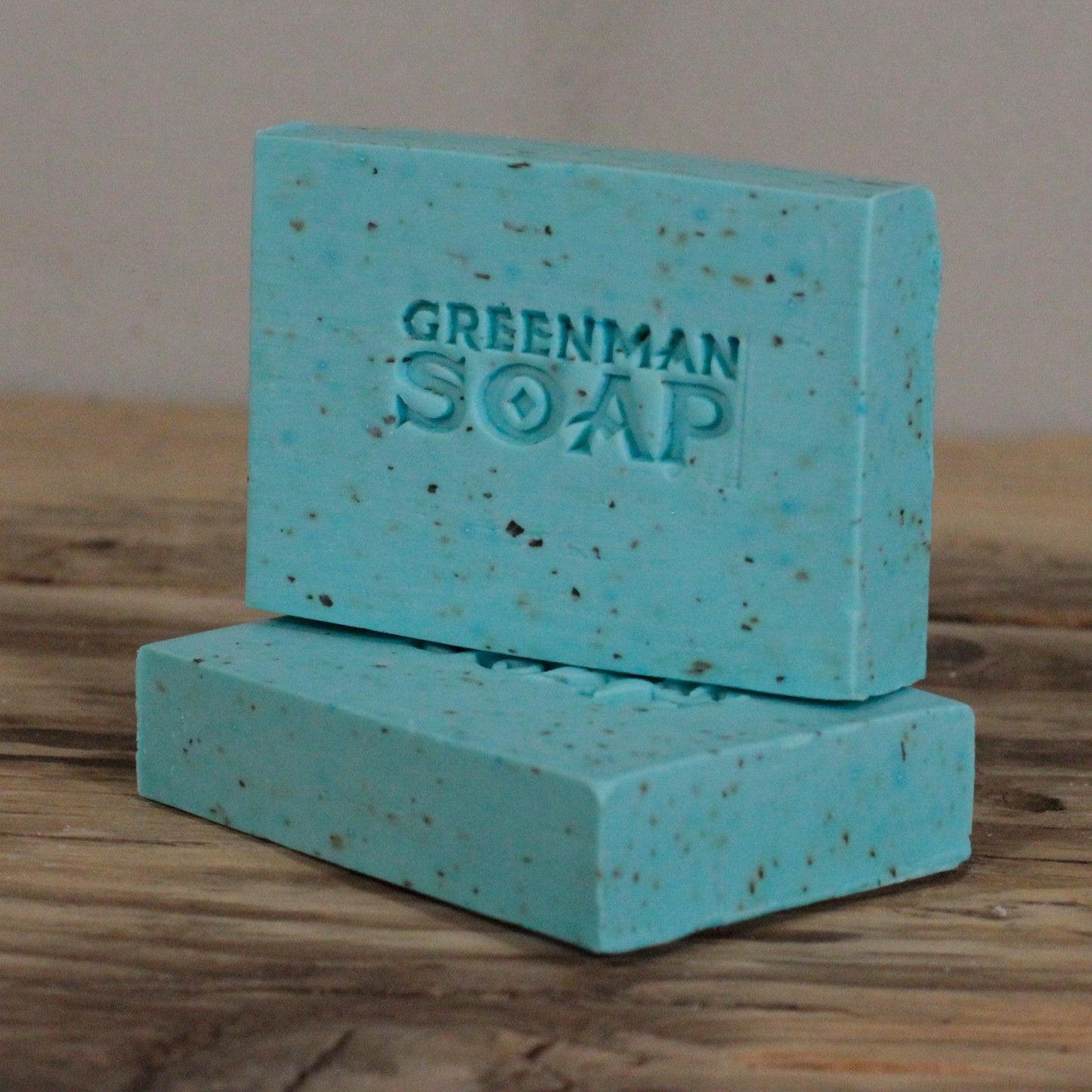 Two bars of Greenman Soap on a wooden surface