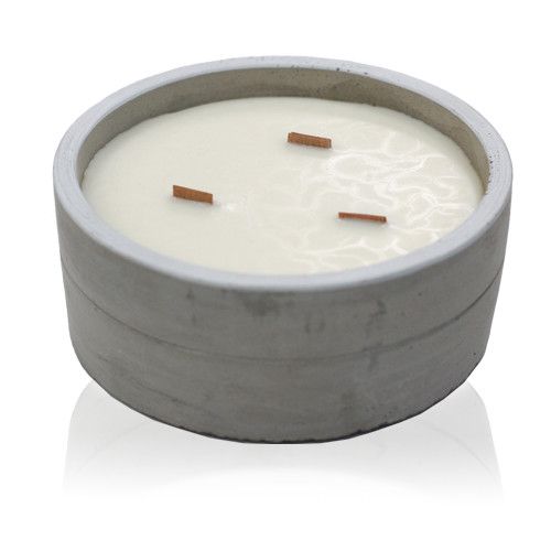 Candle in a concrete holder with three wooden wicks on a white background