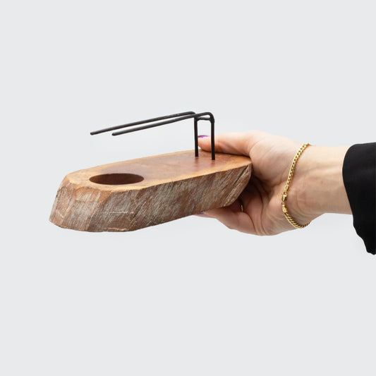 Hand holding Palo Santo Heater  handcrafted  from White Wash Gamel wood with metal supports for holding a smudge stick and an indentation for a tea light