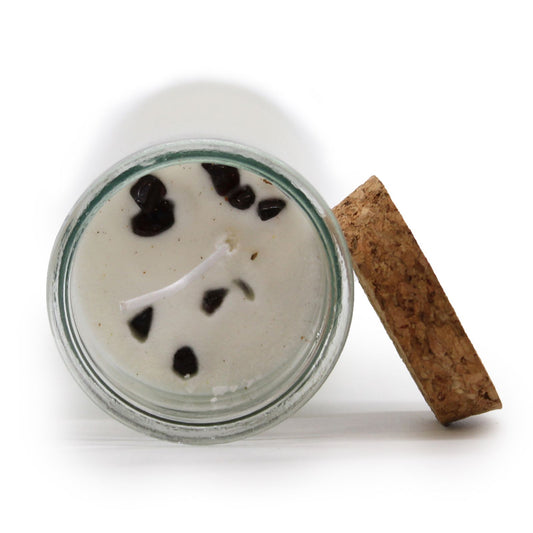 Candle in a glass jar with a cork lid on a white background
