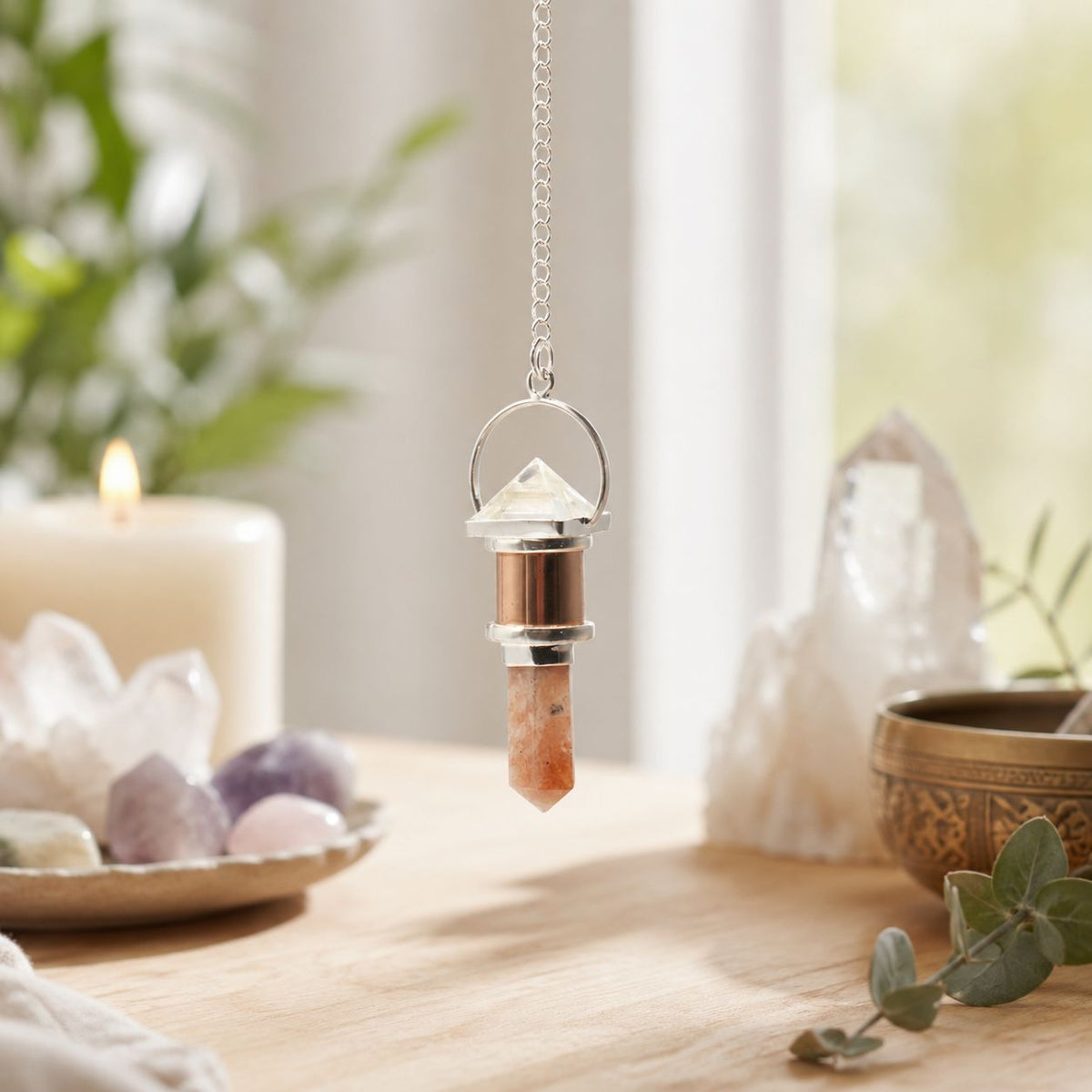 Decorative crystal pendant on a chain with a candle and crystals in the background