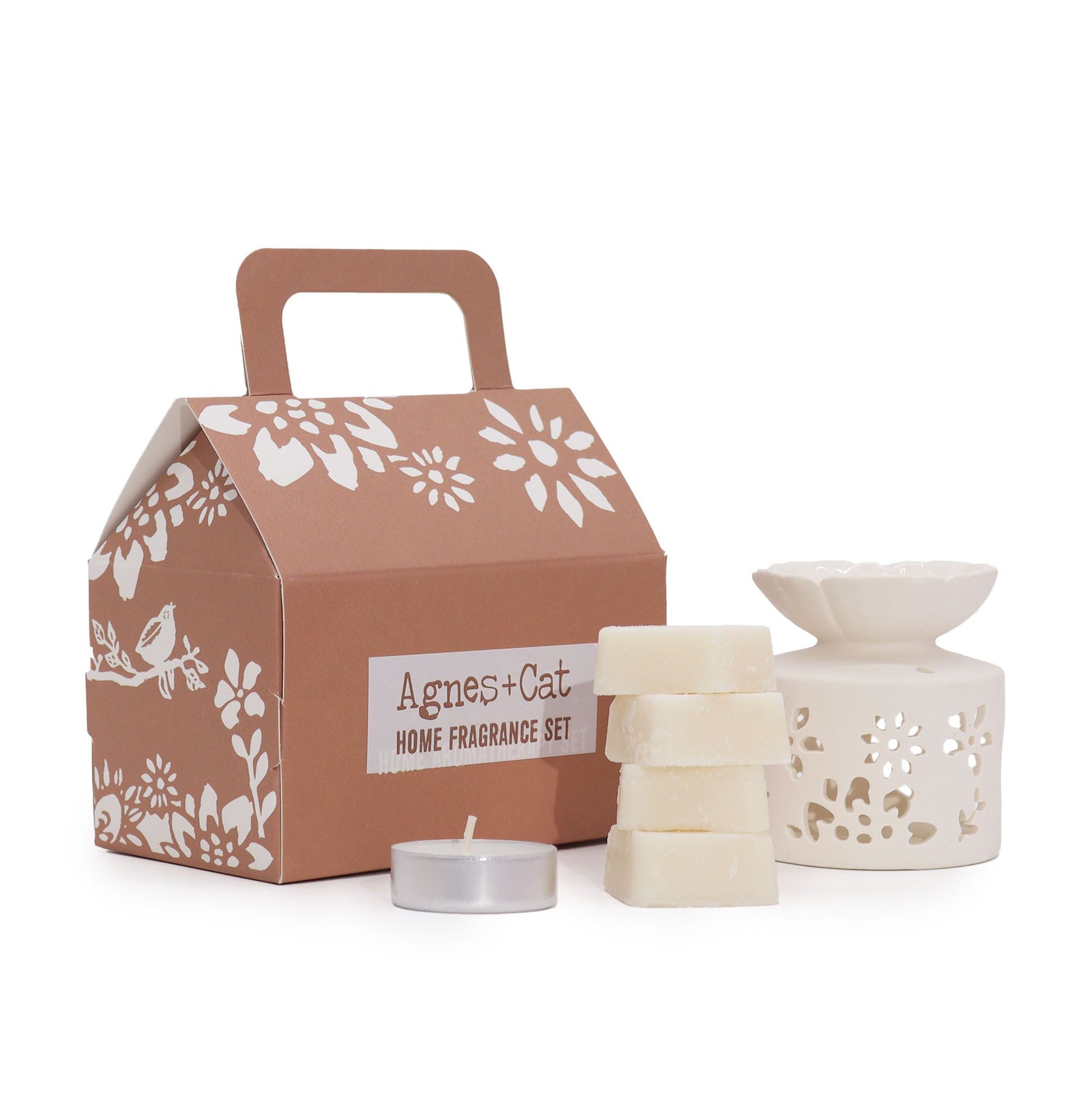 Brown box printed with Agnes + Cat, a white ceramic wax heater,4 wax melts and a tealight