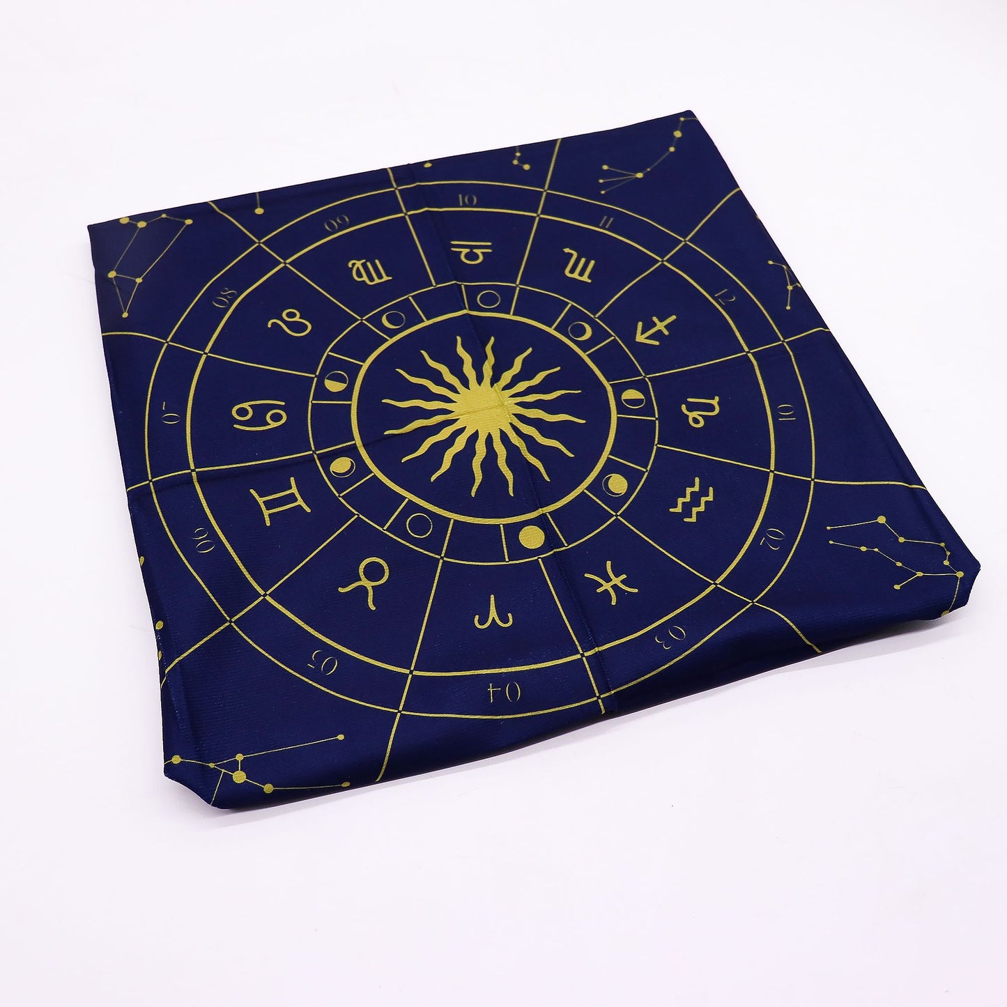 Folded blue fabric with gold astrological symbols on a white background