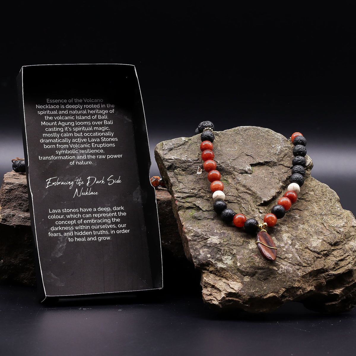 Necklace with beads on a rock next to a descriptive card