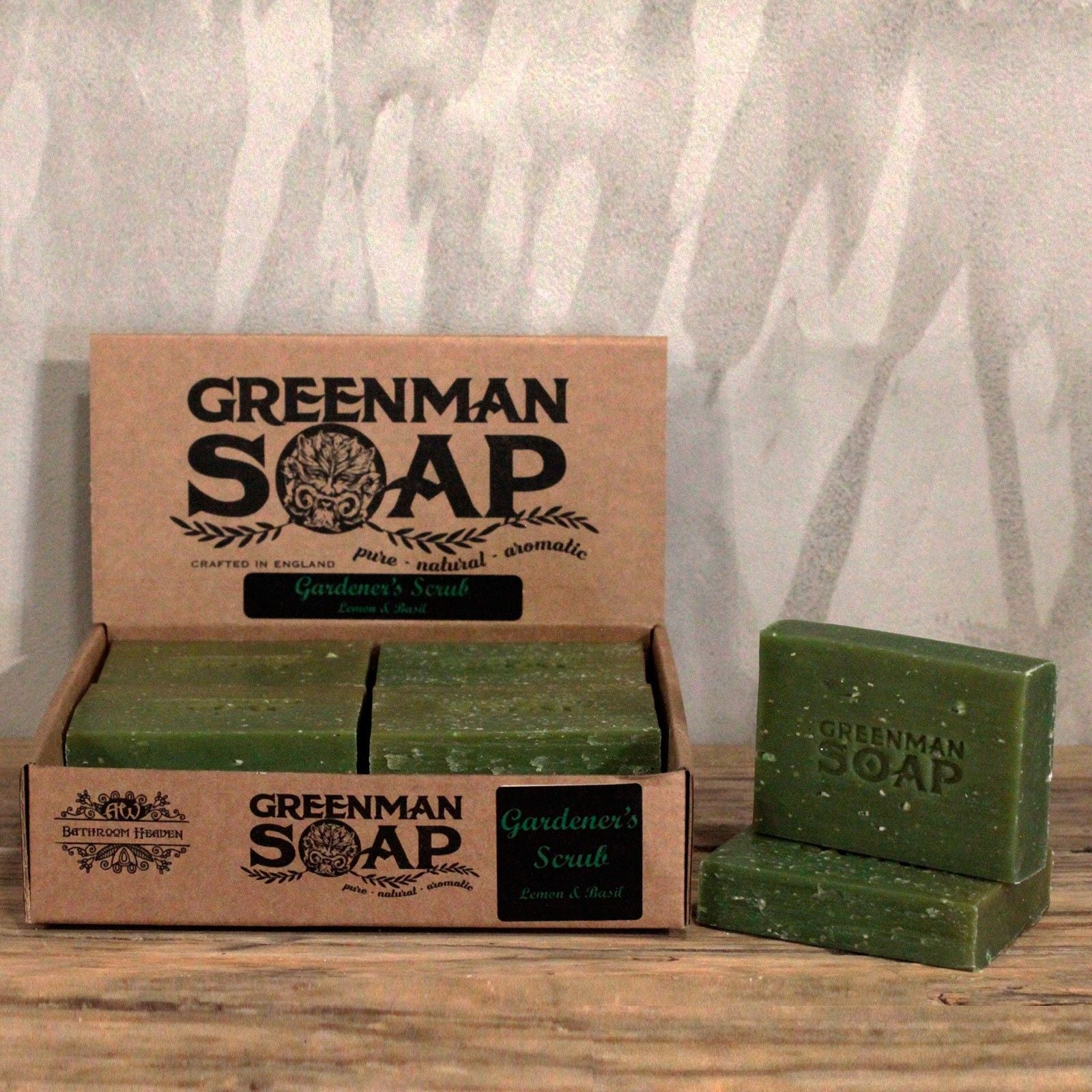 Greenman Soap bars and packaging on a wooden surface with a gray textured background